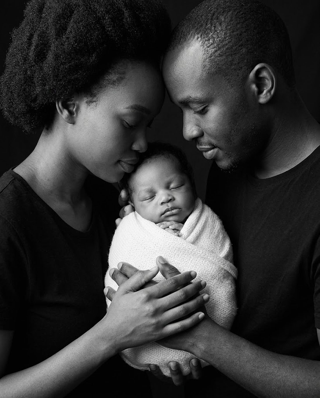 Black and white newborn portrait with mother and father