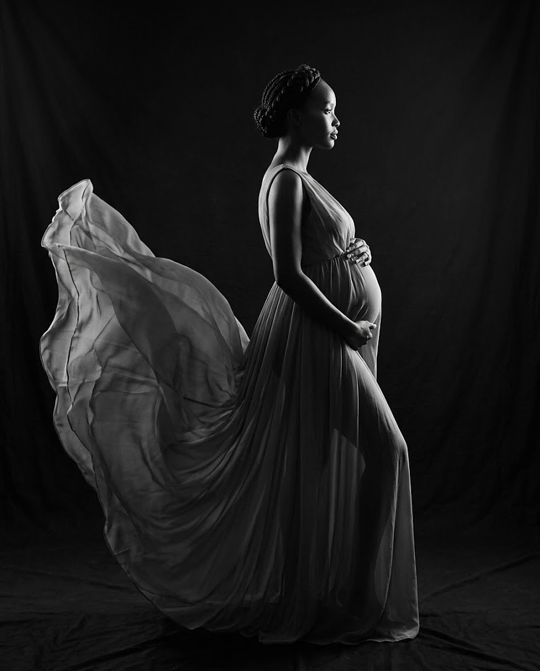 Black and white maternity portrait in a flowing gown